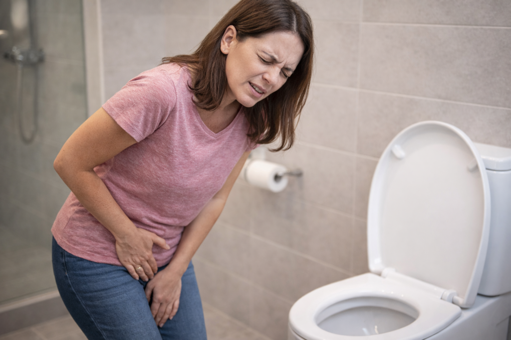 hombre con dolor o ardor al orinar en el baño